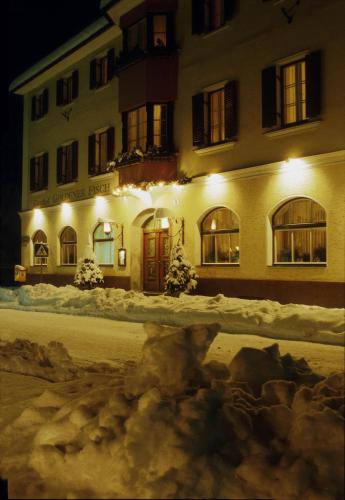 a building with snow in front of it at night at Gasthof Goldener Fisch in Lienz