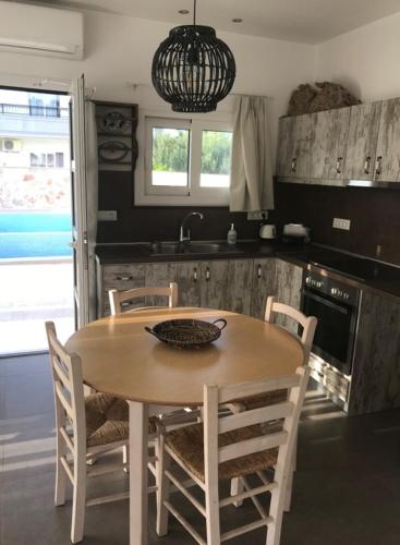 a kitchen with a table and chairs and a sink at Kostas Studios in Faliraki