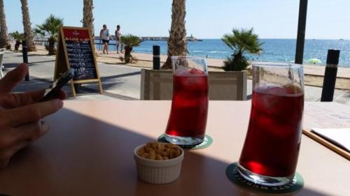 a table with two drinks and a bowl of food at Beach front Esther 1 villajoyosa in Villajoyosa