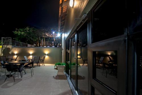 a patio with tables and chairs at night at Ossanzaia Bilene Lodge in Vila Praia Do Bilene