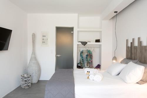 a bedroom with a large white bed with white pillows at Merchia Bay Villas Mykonos in Merchia Beach