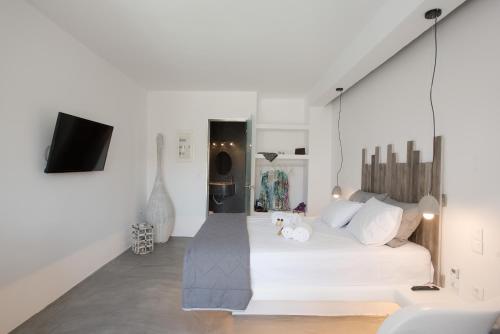 a white bedroom with a large white bed with white pillows at Merchia Bay Villas Mykonos in Merchia Beach