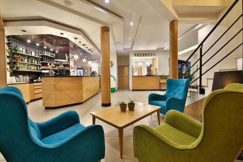 a lobby of a store with blue and green chairs at Hotel Kompleks Beskid z basenem i stokiem narciarskim - blisko Babiej Góry in Spytkowice