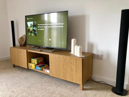 a flat screen tv sitting on top of a wooden entertainment center at Stelvio in Aviemore