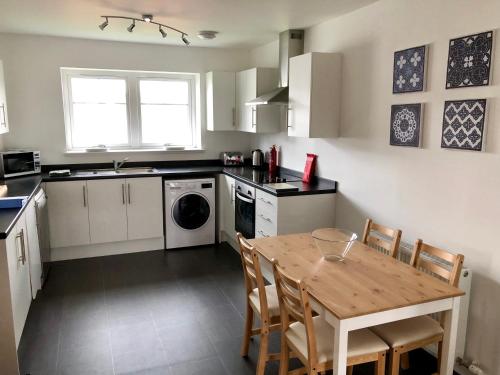 a kitchen with a wooden table with chairs and a sink at Stelvio in Aviemore
