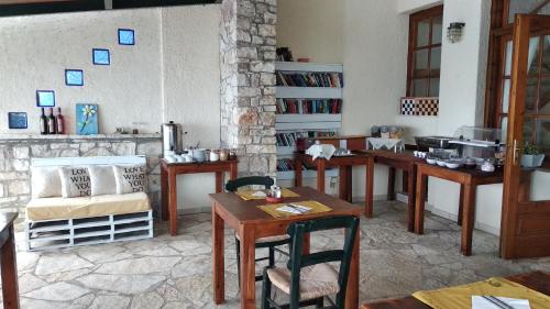 a room with tables and chairs and a fireplace at Grekis Beach Hotel and Apartments in Petalidhion