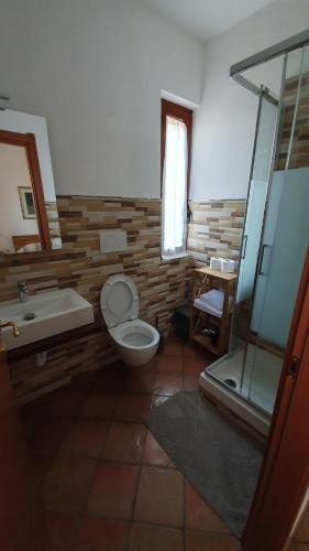 a bathroom with a toilet and a tub and a sink at Villa Canu in Alghero