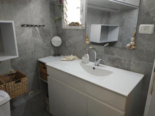 a bathroom with a white sink and a mirror at Studio Apt Great Location Heart of Downtown District in Haifa