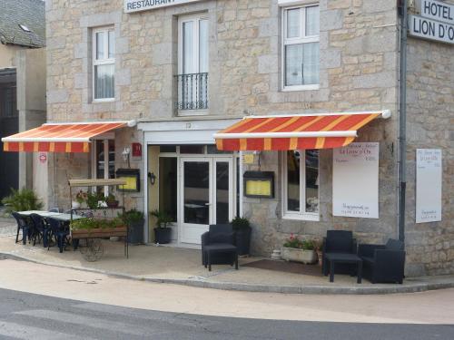 un restaurante con mesas y sillas frente a un edificio en le lion d'or, en Saint-Chély-d'Apcher