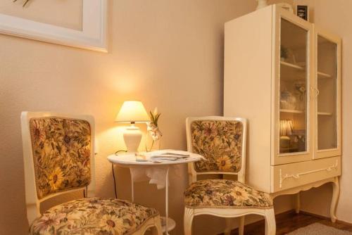 Habitación con 2 sillas, mesa y armario en Apartment City Center Amaryllis, en Rovinj