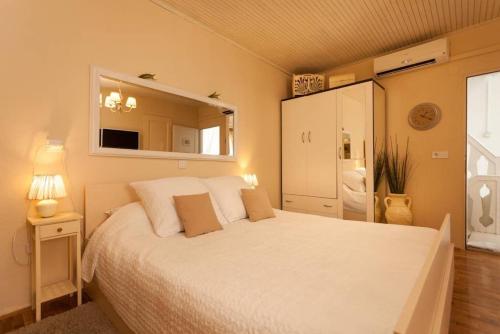 a bedroom with a large white bed and a bathroom at Apartment City Center Amaryllis in Rovinj