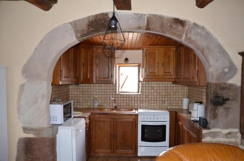 une voûte dans une cuisine équipée d'un four avec plaques de cuisson blanches dans l'établissement Maison tout confort calme vallée du Lot proche de Conques en Aveyron, à Las Pelies