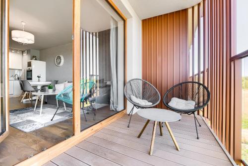 a room with two chairs and a table on a balcony at Blue Mare Natura Resort z parkingiem i rowerami in Kołobrzeg