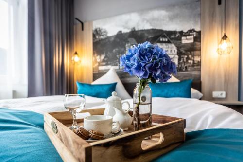 a tray with a blue flower on a bed at Villa Sachsenhof - Pension - Frühstück buchbar - nur 700m vom Gesundheitsbad ACTINON in Bad Schlema