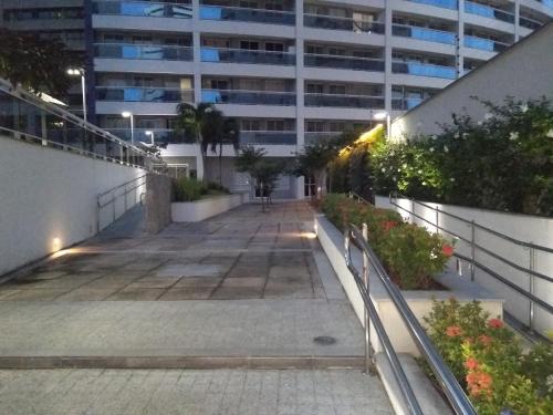 a walkway in front of a building at night at Apartamento 2 quartos May Way Meireles uma quadra da Beira-mar in Fortaleza