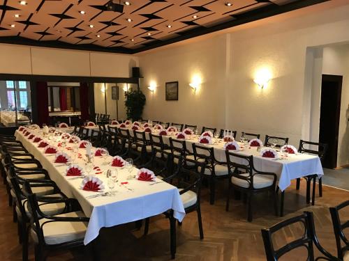 a banquet hall with tables and chairs with roses on them at Hotel & Restaurant Schenk von Landsberg in Teupitz