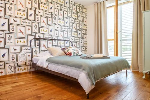 een slaapkamer met een bed en een muur met foto's bij Kopu Vetrunges - Nida Apartments in Nida
