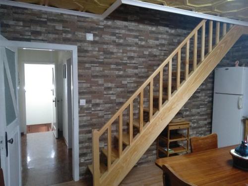 a staircase in a living room with a brick wall at Vivenda "Porto de Abrigo" in Biscoitos