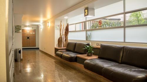 a waiting room with a leather couch in a building at Hotel Milan CDMX in Mexico City