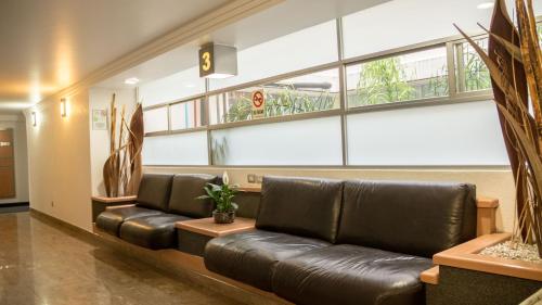 a lobby with a leather couch in a waiting room at Hotel Milan CDMX in Mexico City