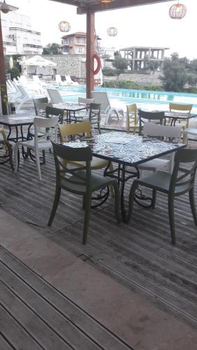 a group of tables and chairs on a deck at Olives Residence in Dhërmi