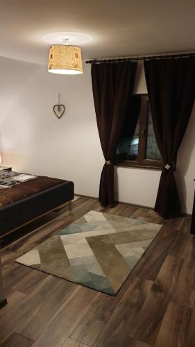 a bedroom with a bed and a rug on the floor at River Star in Sîngeorgiu de Pădure
