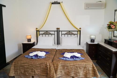 a bedroom with a bed with two towels on it at Vasilaras Hotel in Skala