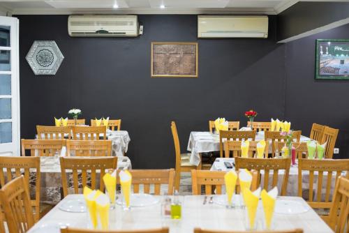 a dining room with tables and chairs with yellow bows at Taka-Taka in Maputo