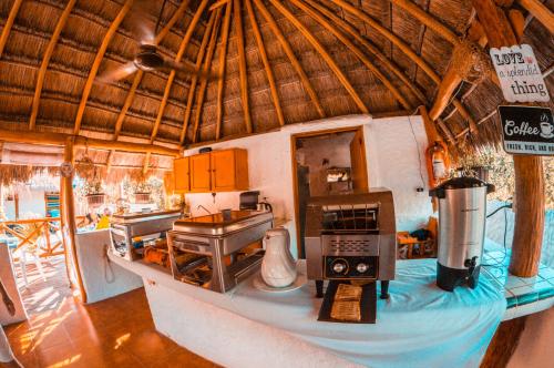 a kitchen in a straw hut with a appliance on a counter at Ensueño Holbox & Beach Club in Holbox Island