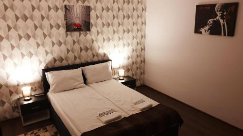 a small bedroom with a bed and two night stands at River Star in Sîngeorgiu de Pădure