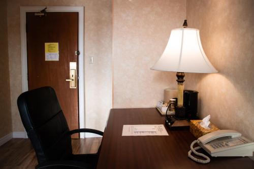 a desk with a lamp and a telephone and a phone at Royal Inn and Suites at Guelph in Guelph