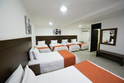 a room with a bunch of beds in it at Hotel Arawak Upar in Valledupar