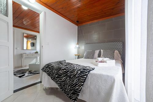 a bedroom with a zebra print bed in a room at Casa Branca in Angra do Heroísmo