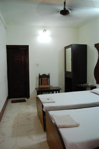 a room with two beds and a mirror and a door at Sai Palace in Agra