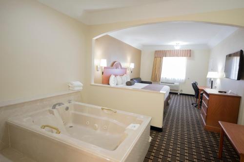 a hotel room with a tub and a bed at Motel 6-Tyler, TX in Tyler