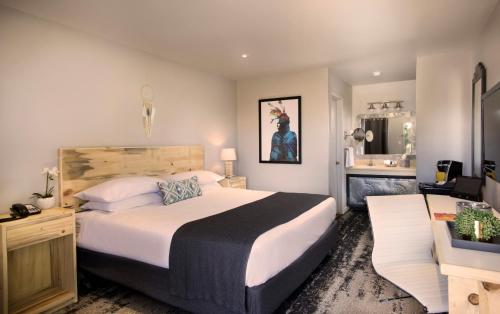 a hotel room with a large bed and a bathroom at The Sage Hotel in Santa Fe