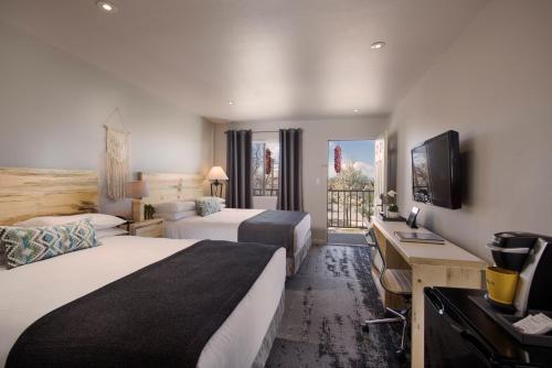 a hotel room with two beds and a television at The Sage Hotel in Santa Fe