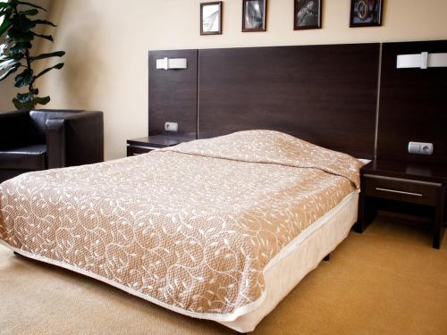 a bedroom with a large bed with a large headboard at Hotel Kuźnia in Bydgoszcz