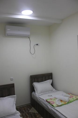 a bedroom with two beds and a light on the wall at Green Palma in Kutaisi