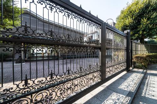 a black wrought iron gate in front of a building at the salon 伊豆高原 Hotels & Resort in Ito