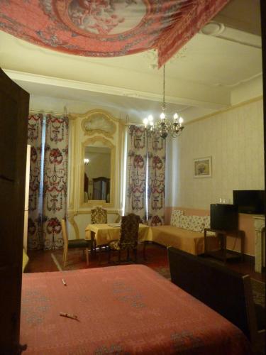 a living room with a couch and a mirror at Hôtel du Fiacre in Carpentras