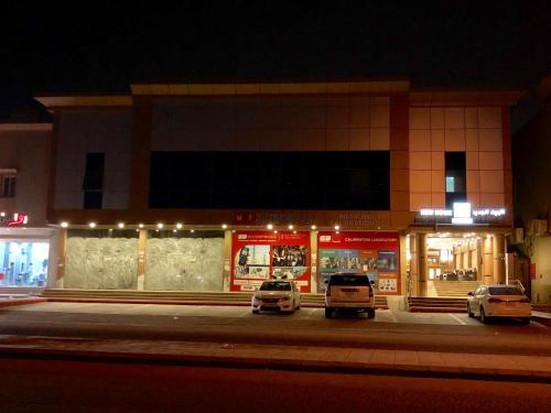 una tienda con autos estacionados frente a ella por la noche en New Home Furnished Units en Yanbu