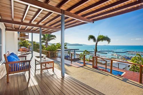 an outdoor deck with a view of the ocean at Nautilus On The Hill - Airlie Beach in Airlie Beach
