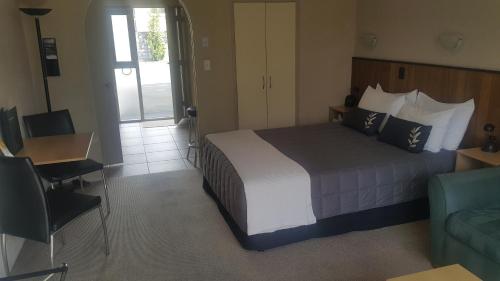 a bedroom with a bed and a desk and a couch at 299 On Devon West in New Plymouth