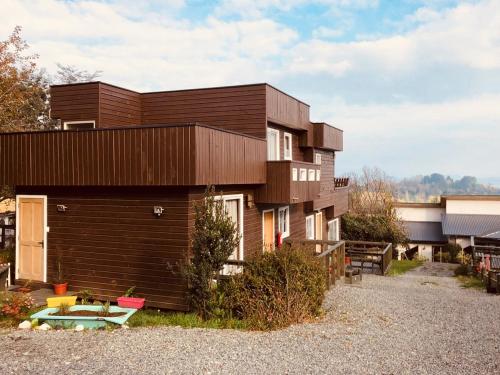 a wooden house with a small yard in front of it at Dulac Futrono in Futrono