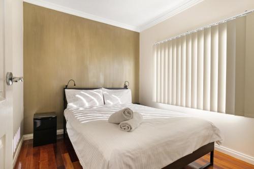 a bedroom with a bed with two towels on it at The Bud House in Rosebud