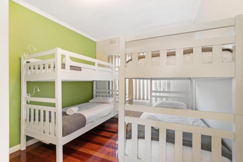 two bunk beds in a room with green walls at The Bud House in Rosebud