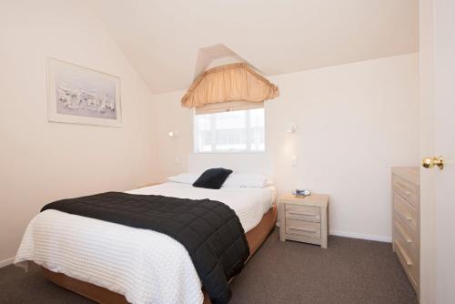 a small bedroom with a bed and a window at Waimarie on Riverside Motel & Apartments in Nelson