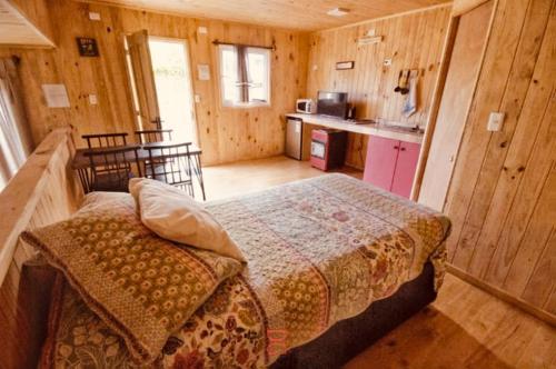 um quarto com uma cama num quarto de madeira em Dulac Futrono em Futrono