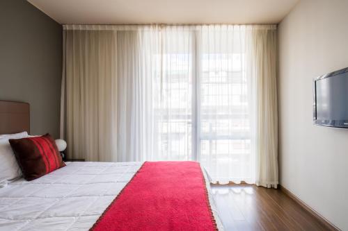 a bedroom with a bed with a red rug and a window at Palermo Soho Square in Buenos Aires
